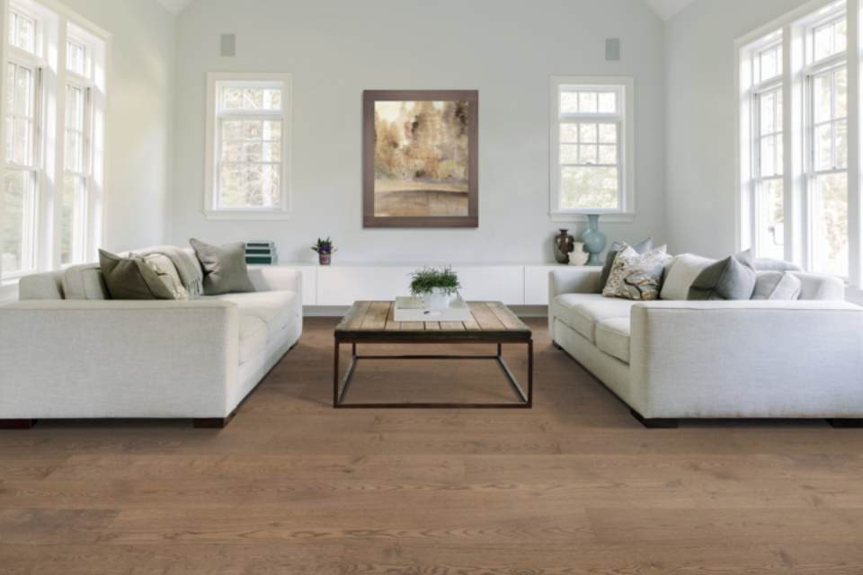 Dark hardwood flooring in living room with white couches and brown coffee table.